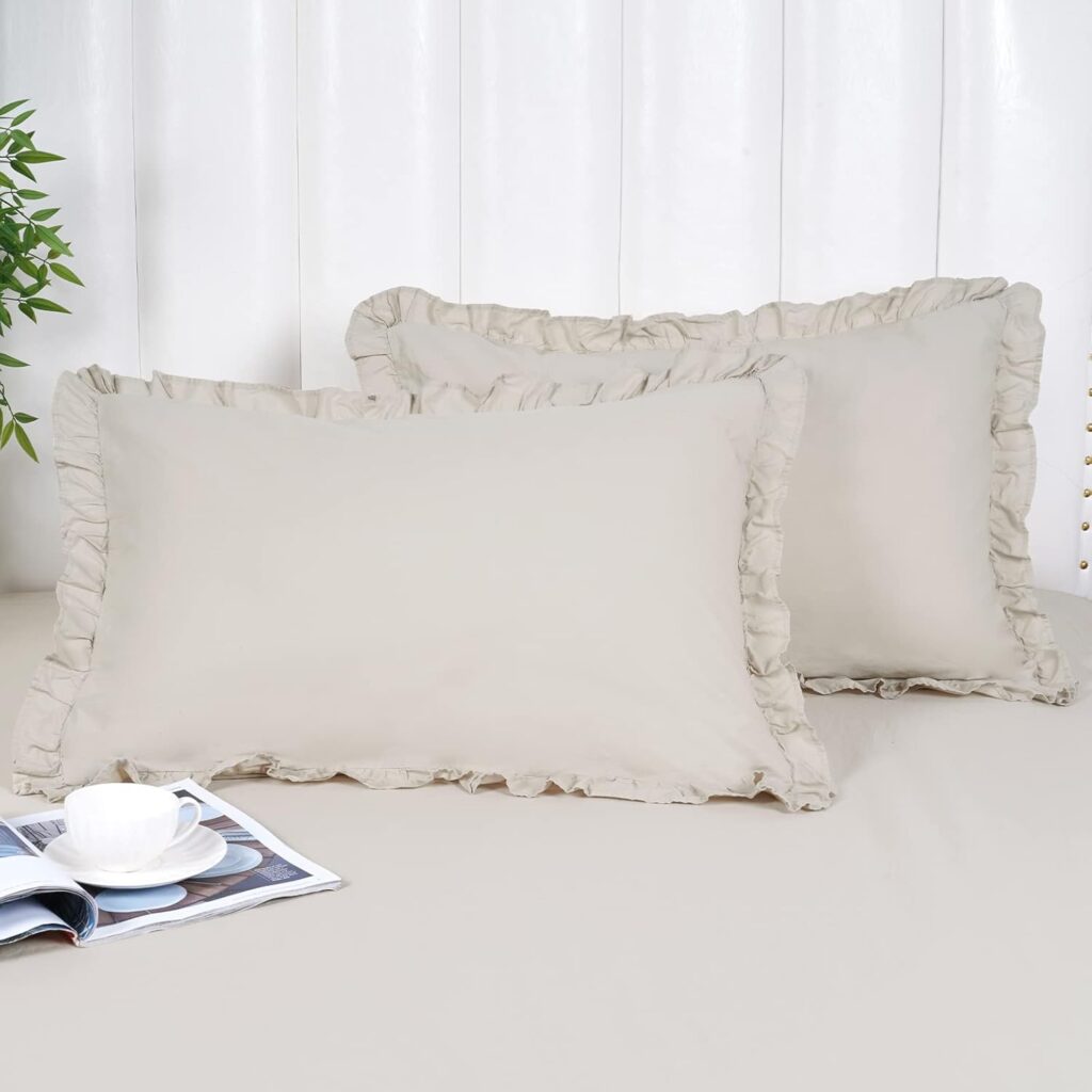 Two oatmeal-colored standard size cotton pillow shams with delicate ruffled edges displayed on a bed, offering a soft romantic cottage aesthetic.