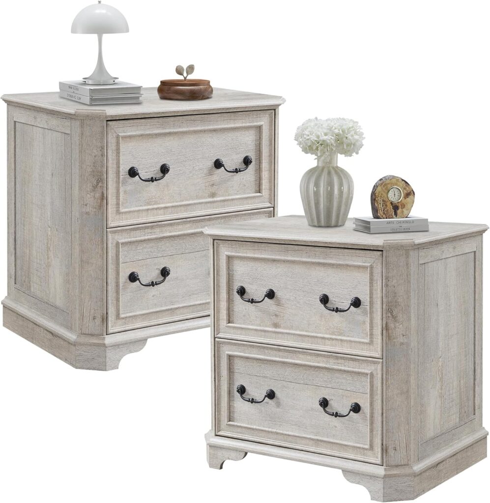 Distressed light oak nightstands with curved edges and black metal handles, styled with vase and lamp on top in a romantic cottage bedroom setting